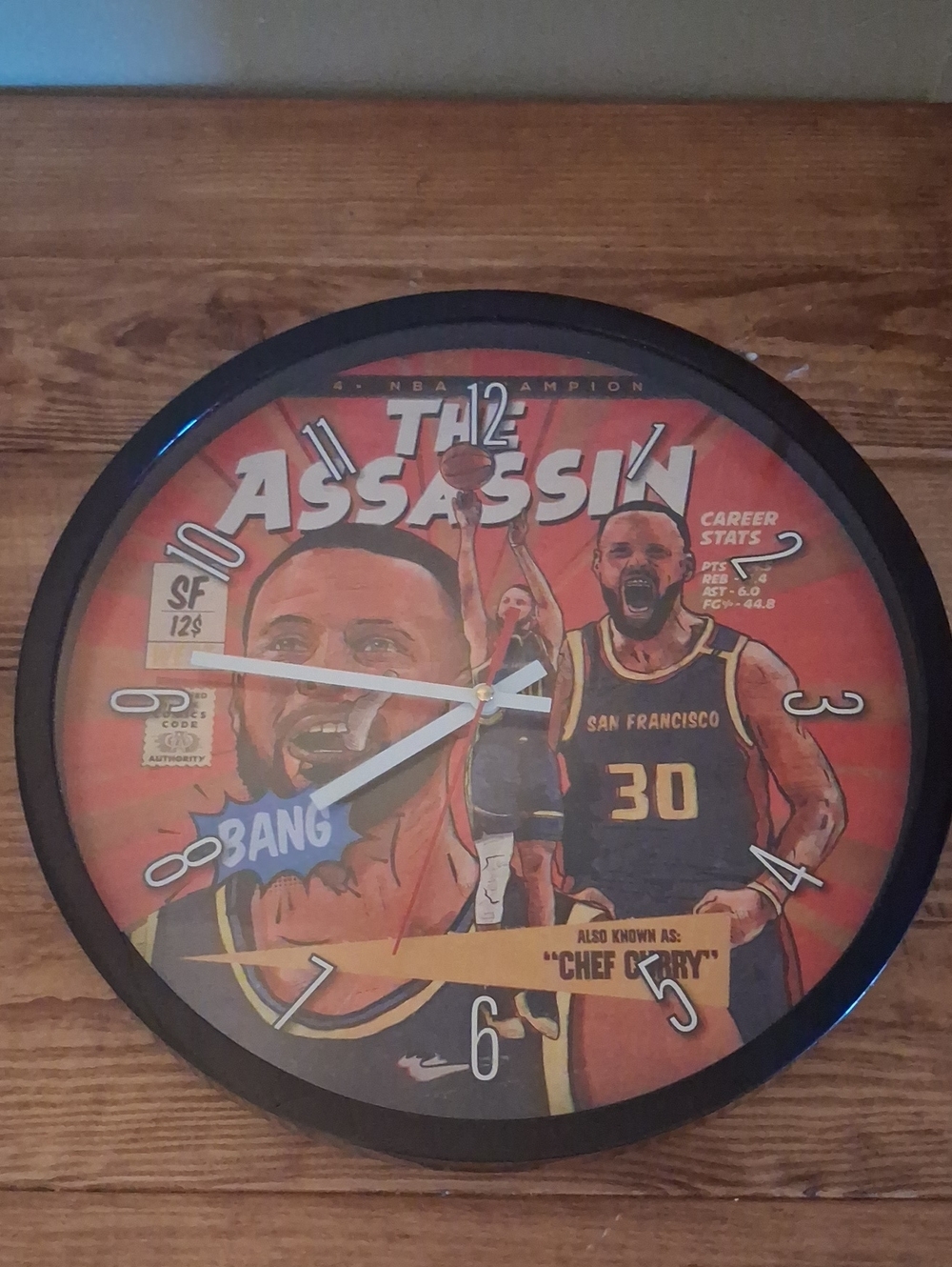 The Assassin Chef Curry Wall Clock - Black Frame, Orange Graphic